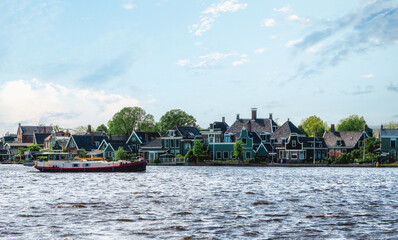 Fototapeta na wymiar Traditional Zaan houses with the painted wooden facades on the banks of the river Zaan.