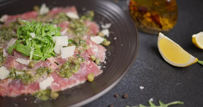 tuna carpaccio - slices of fresh raw tuna fillet on black ceramic plate
