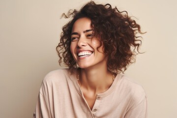 Portrait of a happy young woman with curly hair smiling at camera