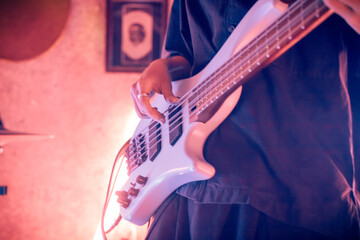 Closeup photo of 5 string bass being played live in a neon mood live music show