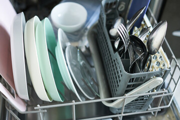 Dishwasher machine with clean utensils, close-up