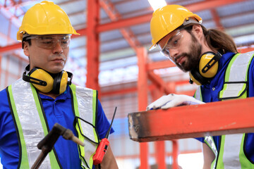 Man worker welder welding steel structures inside buildings of industrial plants in construction...