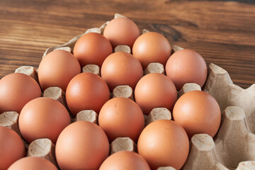 Eggs in a carton on a wooden background. Close-up.