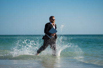 Excited millennial hispanic business man in suit on sea. Summer vacation, business on sea beach....