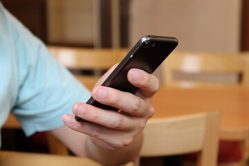 cafeでスマートフォンを触る男性