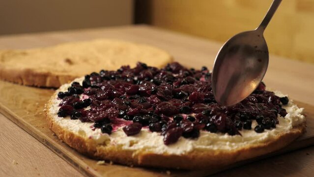 Adding the filling to the cake. Cooking a festive pie at home. Slow motion.