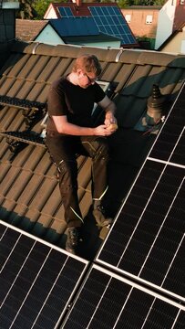 Arc Shot of a Technician on a Roof of a House Checking the Solar Panels