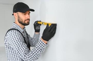 Young worker making repair in room.