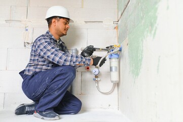 Indian plumber installing water equipment - meter, filter and pressure reducer