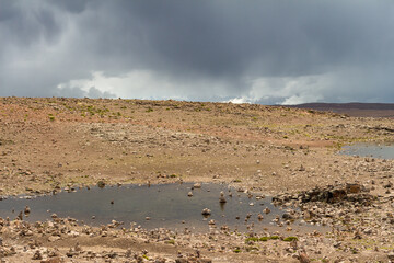 Rocky plateau in the Peruvian Altiplano in the Andes Mountains between Cabanaconde and Arequipa, Peru. Stormy sky, dark clouds.