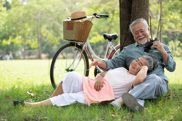 senior couple relaxing together and senior woman lying on the lap of her husband in the park