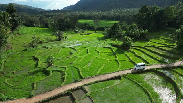 Traveling by minivan car in Sri Lanka or Asia. Road trip in rural asia among rice paddy terraces
