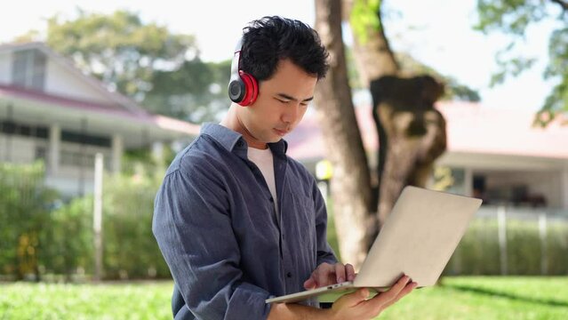 Young Asian students wearing headphones Study and work passionately with a laptop to prepare financial management reports at university.