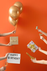 Female hands with gifts, champagne and decor for birthday celebration on color background