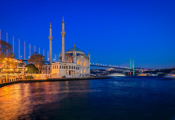 Fototapeta na wymiar Picturesque cityscape with the Bosphorus Strait and the Grand Mecidiye Mosque Ortakoy Mosque and the Bosphorus Bridge Istanbul, Turkey at sunset