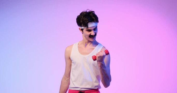Focused retro vintage nerdy Caucasian mustachioed young man making bicep exercise with dumbbells during bodybuilding training over purple background.