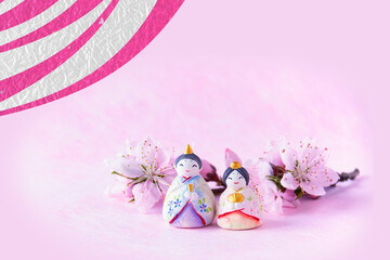 雛祭りのおひな様と桃の花（和紙のピンクバック・波型の合成画像）