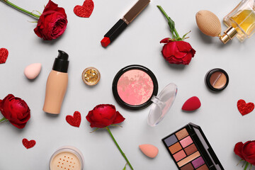 Obraz na płótnie Canvas Cosmetic products with red roses and hearts on white background. Valentine's day celebration