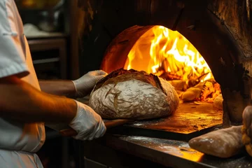 Foto auf Acrylglas Brot chef bakes bread in a woodfired oven