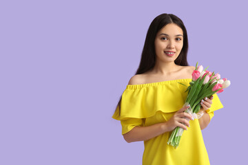 Pretty young Asian woman with bouquet of beautiful tulips on purple background. International Women's Day