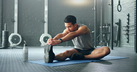 Obraz na płótnie Canvas Man, break and stretching on gym floor in fitness, workout or training for strong muscles, heart health or cardio wellness. Japanese personal trainer, sports person or coach in body warmup exercise