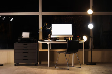 Interior of modern office with workplace, blank computer and glowing lamps - obrazy, fototapety, plakaty