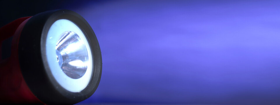 Flashlight, close up, under dark blue background with light beam