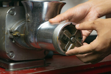 a man attaching grinder blade or cutting blade to a meat grinder