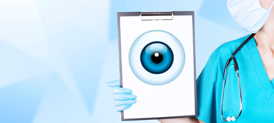 Realistic human eye with a blue cornea in the form of a round icon on a tablet in the hands of a...