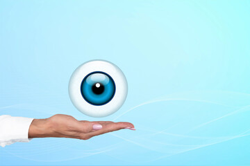 Realistic human eye with blue cornea in the form of a round icon on the palm of a doctor, woman. Gradient blue background. Copy space.