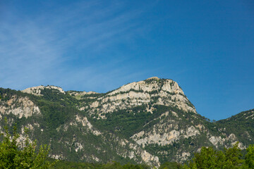 A beautiful morning landscape of a mountain range with a prominent peak against the blue sky. Copy space.