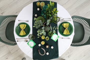 Festive table serving with candles in dining room, top view. St. Patrick's Day celebration