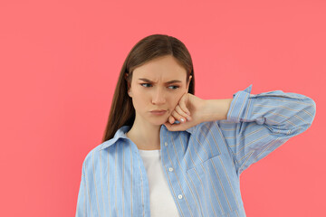 Fototapeta premium Attractive young girl stands on a pink background