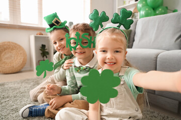 Cute kids celebrating St. Patrick's Day with clovers at home party