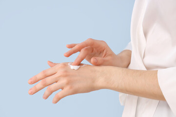 Woman applying natural cream on color background, closeup