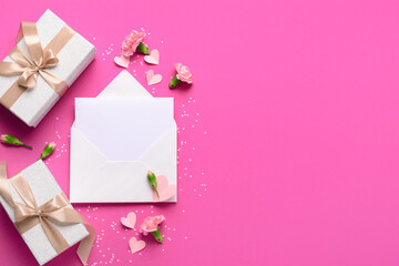 Envelope with blank card, gift boxes and carnation flowers on pink background. International Women's Day celebration