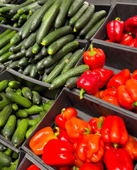 Cucumbers and red paprika on a counter in a market