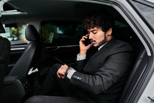 Curly Haired Businessman Backseat Talking Phone