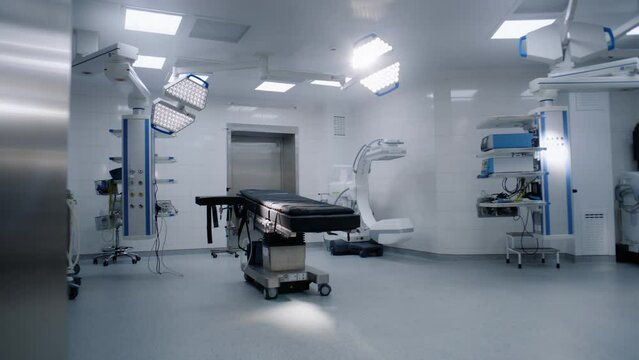 Dolly shot of operating room in modern hospital with advanced equipment for surgery. Operating table, LED lamps, life support and anesthesia machine. Operation block in clinic or medical facility.