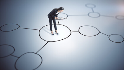 Thoughtful young european businesswoman with magnifier standing on gray background with drawn...