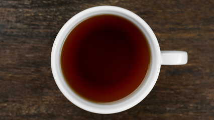 White cup with black tea, top view