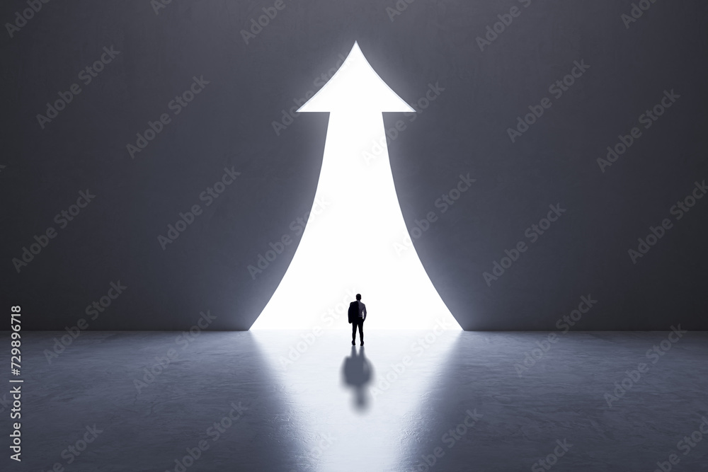 Poster silhouetted figure before an arrow shaped beacon of light on a dark background. direction and aspira