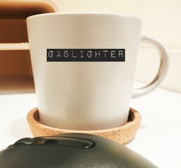 Coffee mug with text written GASLIGHTER, abuser who tries to control victim by twisting their sense...