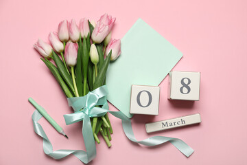 Bouquet and wooden calendar on color background. International Women's Day celebration