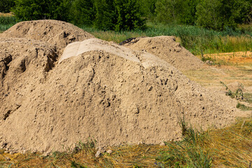 A mountain of sand on a construction site. Foundation material. The soil is prepared to strengthen the soil. Earth heap. Fine sand for leveling and backfilling © PRO Balance