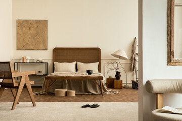 Cozy composition of bedroom interior with mock up poster frame, stylish bed, beige bedding, rattan...