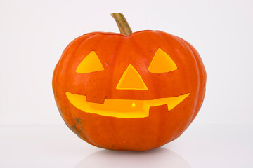 Orange pumpkin with glowing eyes, nose and mouth on a white background. halloween
