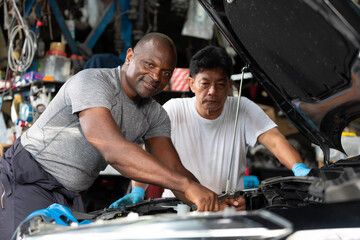 mechanics or workers checking and fixing a car in garage