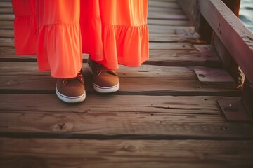 closeup on bright dress hem and casual shoes on a wood pier