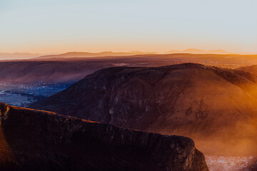 Capturing the breathtaking beauty of a vibrant orange and purple sunset over a majestic mountain during a serene summer evening